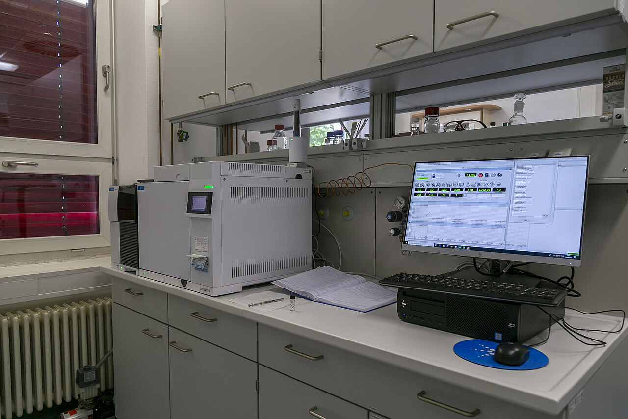 Das Labor. Links ein Gaschromatograph, rechts läuft auf dem Computer das Analyseprogramm.